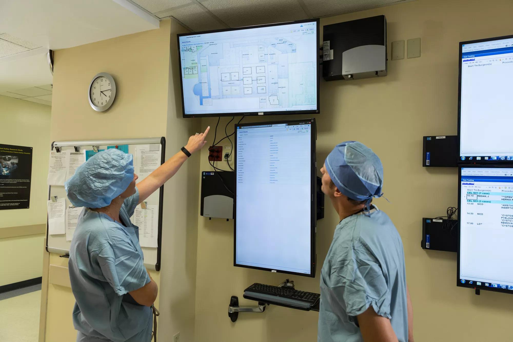 Patient flow doctor and nurse looking at screen of patient locations. Securitas Healthcare.