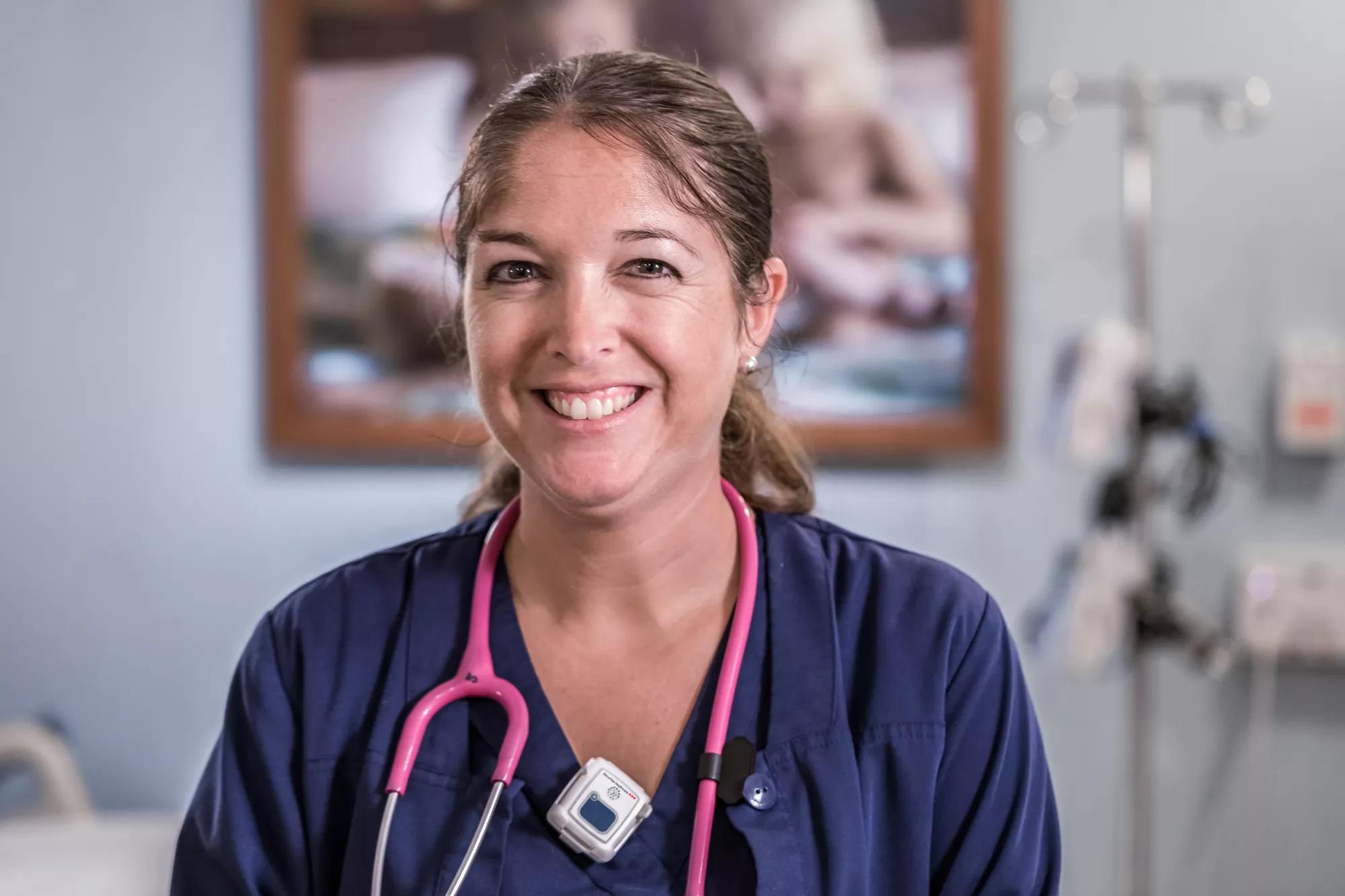 Smiling nurse knows she is protected using a hospital staff protection badge. Securitas Healthcare.