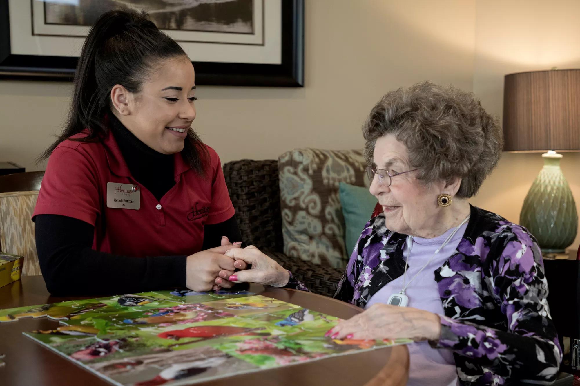 Senior Living community caregiver visits with resident, who uses an Arial e-call pendant by Securitas Healthcare