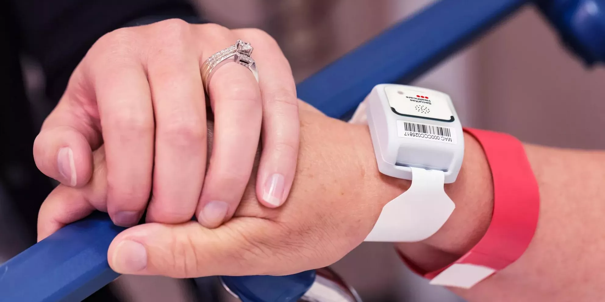 Patient protection T2 tag on a patient wrist, holding hands. Securitas Healthcare.