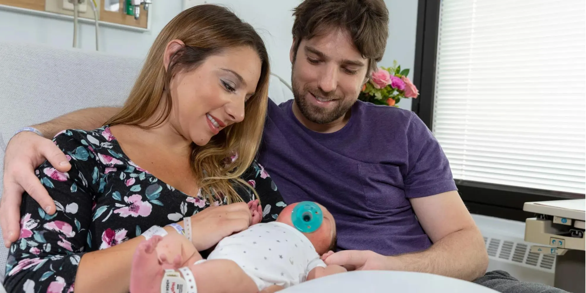 New parents hold their baby, protected by Securitas Healthcare's Hugs infant protection solution