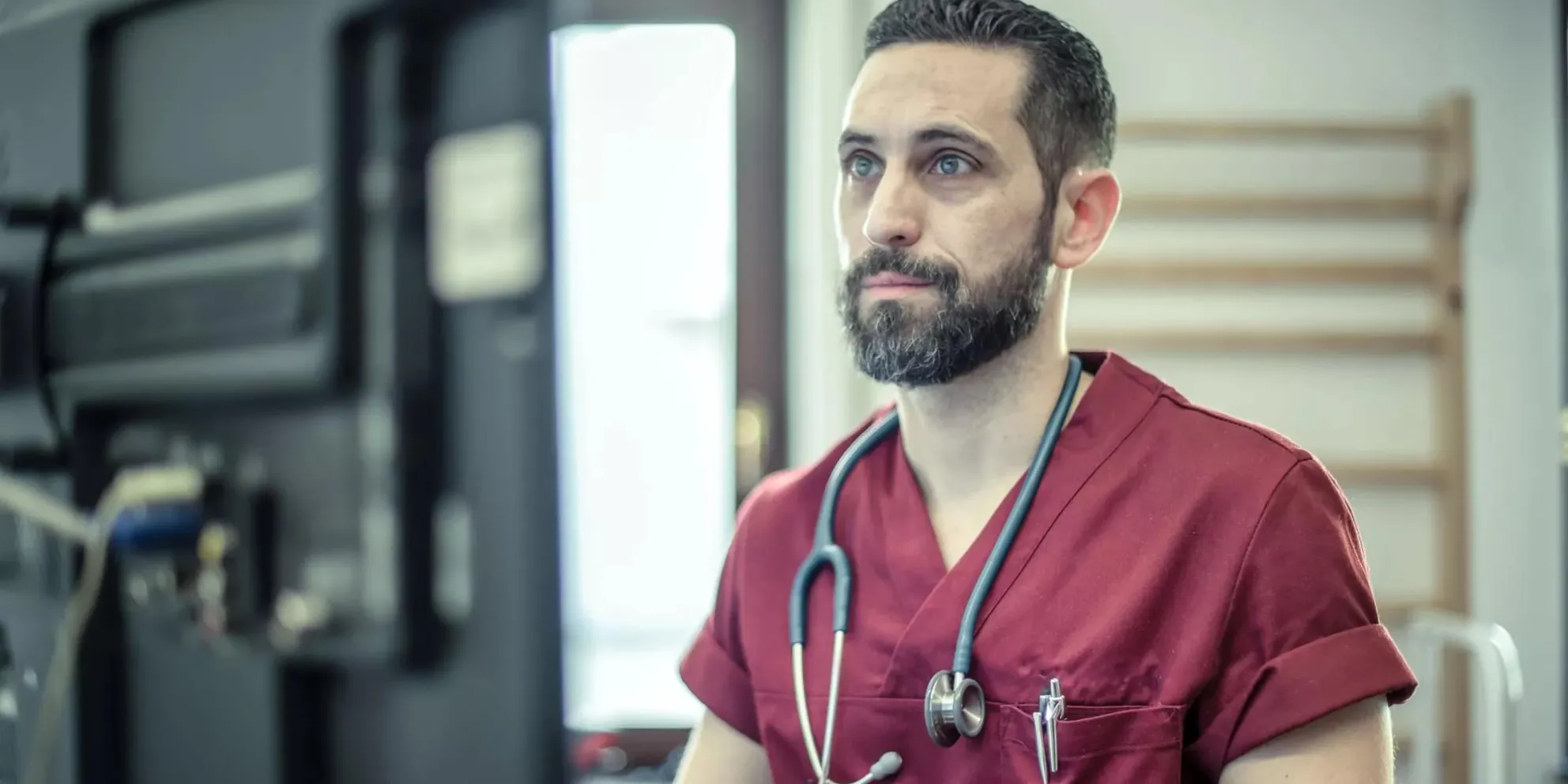 Caregiver wearing scrubs doing tasks on computer