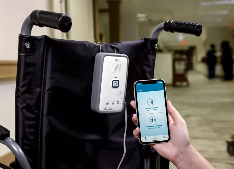 M210 fall management monitor attached to wheelchair with mobile app - Securitas Healthcare.