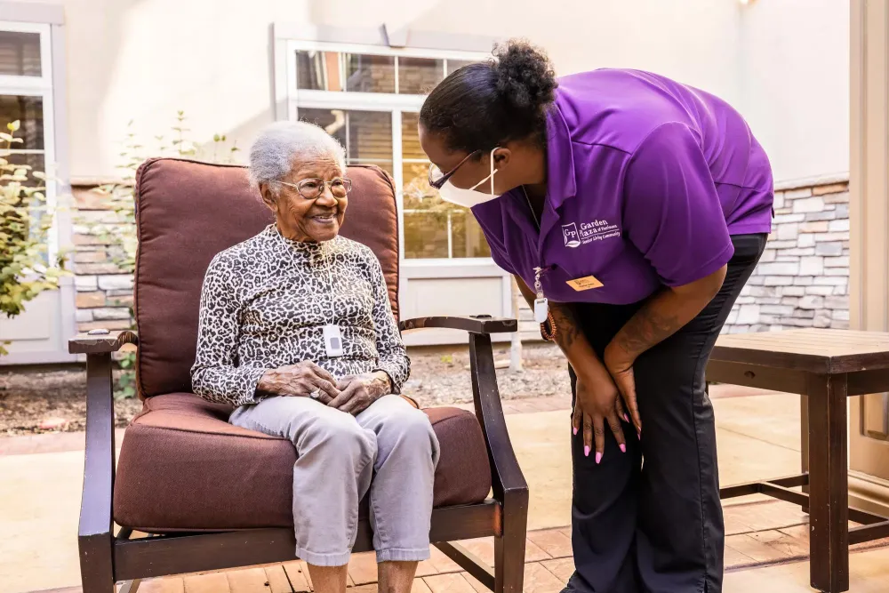 Caregiver checking on senior living resident wearing Arial Wi-Fi pendant. Securitas Healthcare.