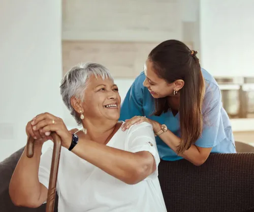 Senior living resident wearing WanderGuard BLUE bracelet is greeted by a community caregiver. Securitas Healthcare
