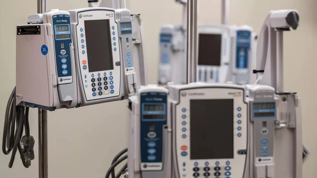 Securitas Healthcare asset management tag on infusion pump near other pumps.