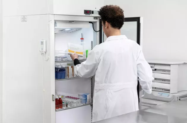Retrieving vaccine from refrigerator monitored by Securitas Healthcare T15 tag