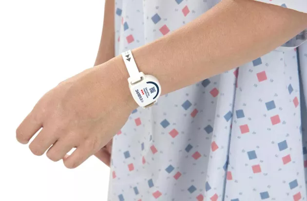 Patient in a hospital gown wearing the T8p Patient Protection band on their wrist. Securitas Healthcare.