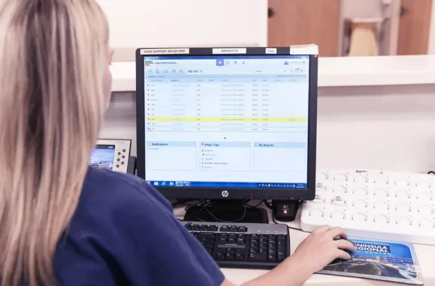 Caregiver operating the Hugs Infant Protection solution on a computer