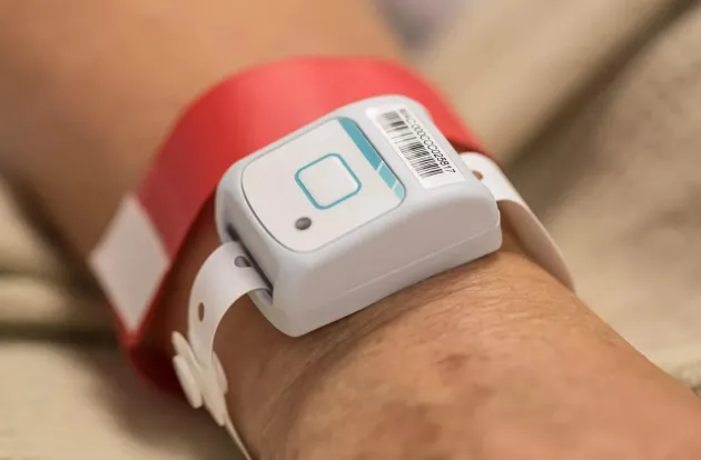 Patient flow band visible on wrist. Securitas Healthcare.