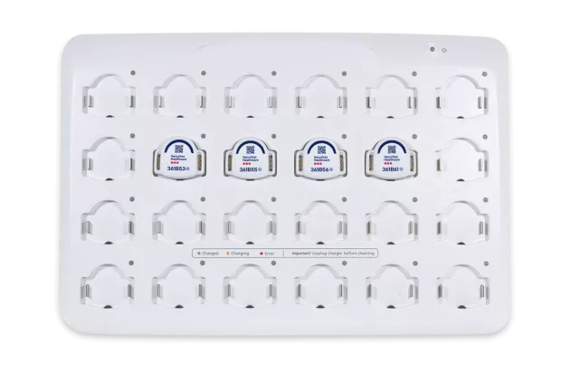 Four Securitas Healthcare T8p patient protection badges in the charging station.