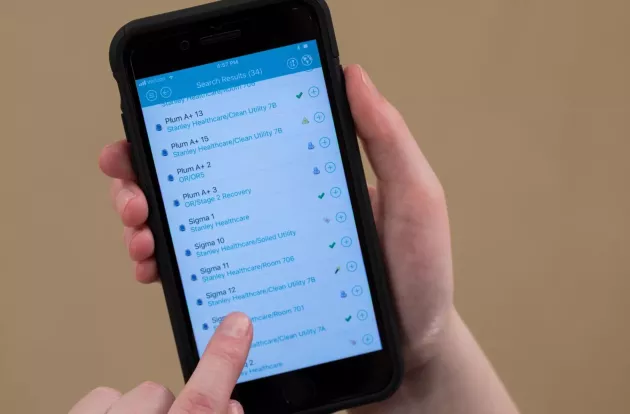 Caregiver scrolling through the MobileView Locator Mobile App on their smartphone device