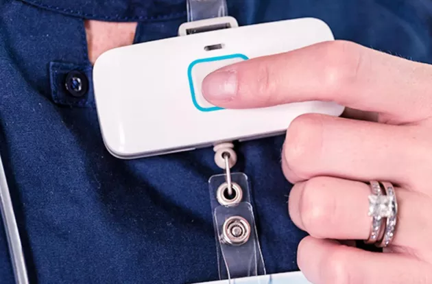 Caregiver pressing button on Securitas Healthcare's T3s staff visibility badge.