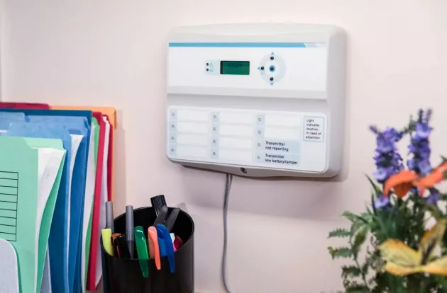 Arial Wireless Remote Annunciator monitoring resident alerts while attached to office wall