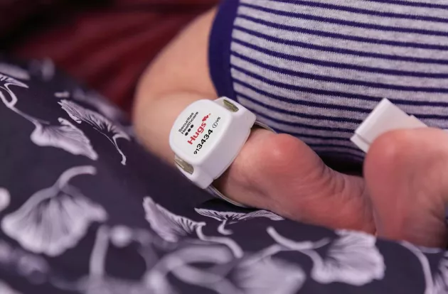 Hugs infant protection tag on a baby's ankle