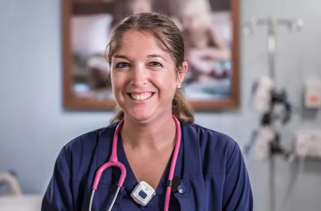 Caregiver smiling while wearing Securitas Healthcare's T14 staff badge.