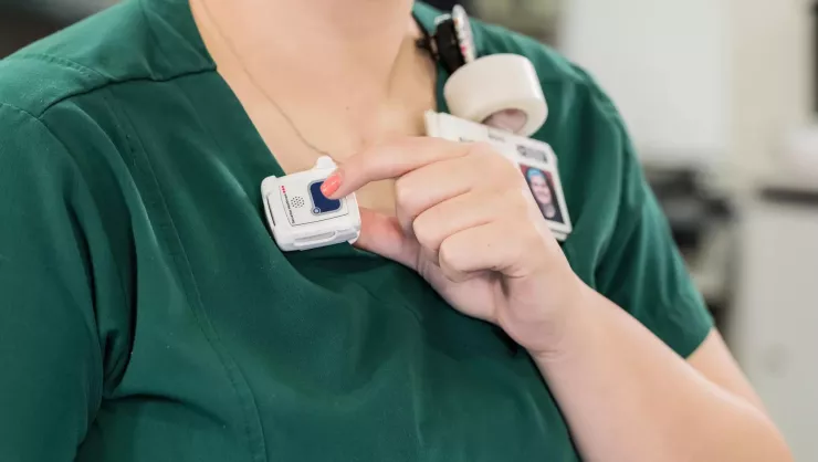 Staff protection badge being shown while the button is pressed. Securitas Healthcare.