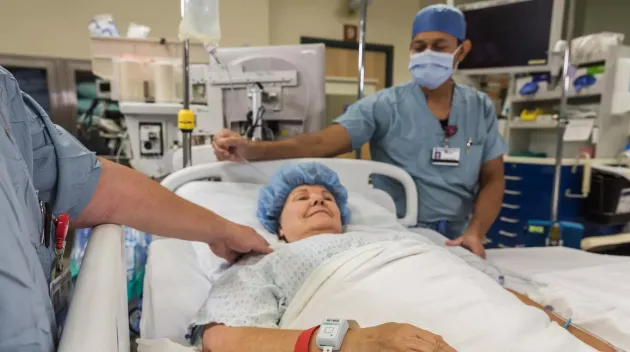 Patient in hospital bed, wearing the Patient flow tag while being cared for. Securitas Healthcare. 