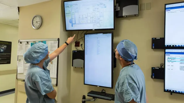Patient flow doctor and nurse looking at screen of patient locations. Securitas Healthcare.