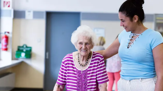 Care giver providing help to a senior in a resident community. Securitas Healthcare. 