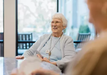 Senior community resident playing cards with friends. Securitas Healthcare