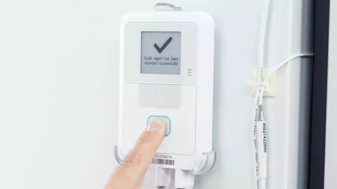 Caregiver pressing the button on the Securitas Healthcare T15e Temperature Monitoring sensor.