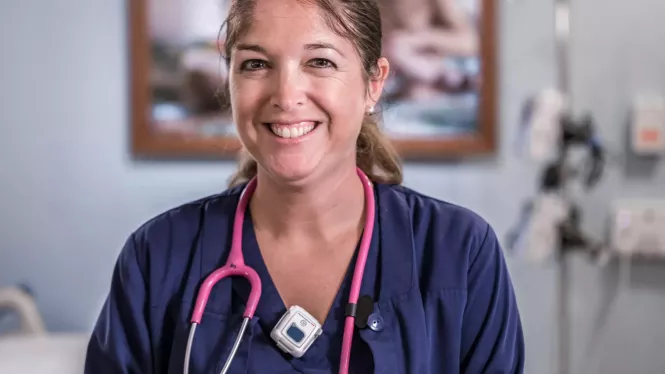 Smiling nurse knows she is protected using a hospital staff protection badge. Securitas Healthcare.