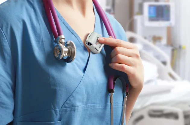 Hospital ICU nurse presses duress button on Staff Protection badge to call for security assistance. Securitas Healthcare.