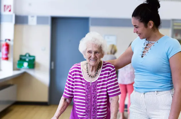 Care giver providing help to a senior in a resident community. Securitas Healthcare. 