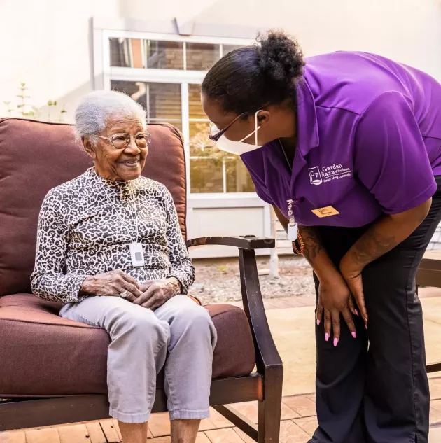 Caregiver checking on senior living resident wearing Arial Wi-Fi pendant. Securitas Healthcare.