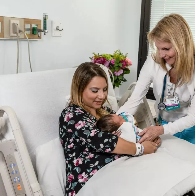 Mom and Baby with nurse in maternity ward. Securitas Healthcare.