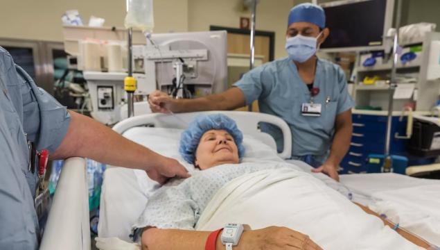 Patient in hospital bed, wearing the Patient flow tag while being cared for. Securitas Healthcare. 