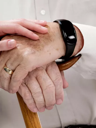 Senior living caregiver holding hand of community resident 
