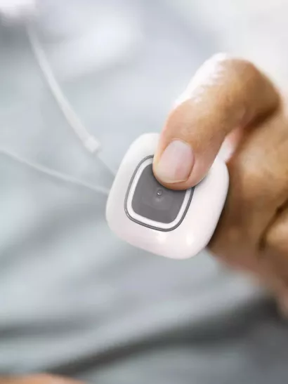 Senior man pressing Securitas Healthcare Arial emergency call pendant to call for help