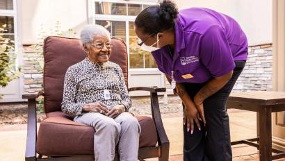 Caregiver checking on senior living resident wearing Arial Wi-Fi pendant. Securitas Healthcare.