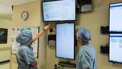 Patient flow doctor and nurse looking at screen of patient locations. Securitas Healthcare.