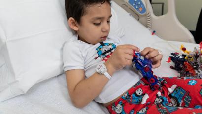 Pediatric patient boy laying in hospital bed wearing the Hugs Infant Protection solution band around his wrist. Securitas Healthcare.