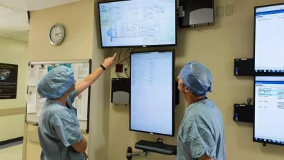 Patient flow doctor and nurse looking at screen of patient locations. Securitas Healthcare.
