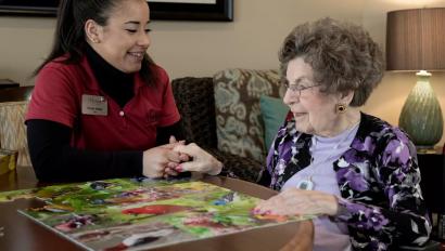 Senior Living community caregiver visits with resident, who uses an Arial e-call pendant by Securitas Healthcare