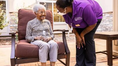 Caregiver checking on senior living resident wearing Arial Wi-Fi pendant. Securitas Healthcare.