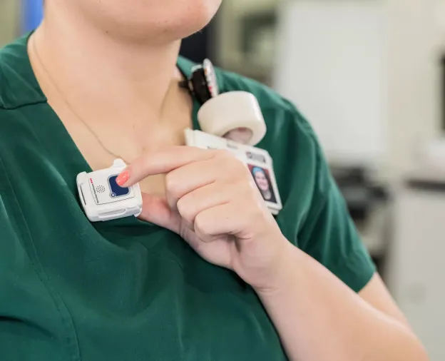 Staff protection badge being shown while the button is pressed. Securitas Healthcare.