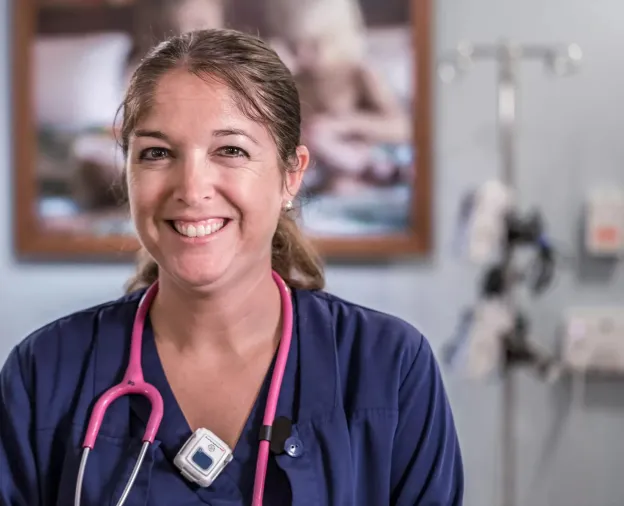 Smiling nurse knows she is protected using a hospital staff protection badge. Securitas Healthcare.