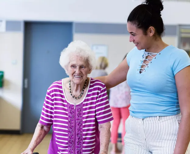 Care giver providing help to a senior in a resident community. Securitas Healthcare. 